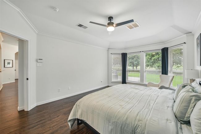 Bedroom featuring ornamental molding, dark wood-type flooring, arched walkways, and ceiling fan | Image 18