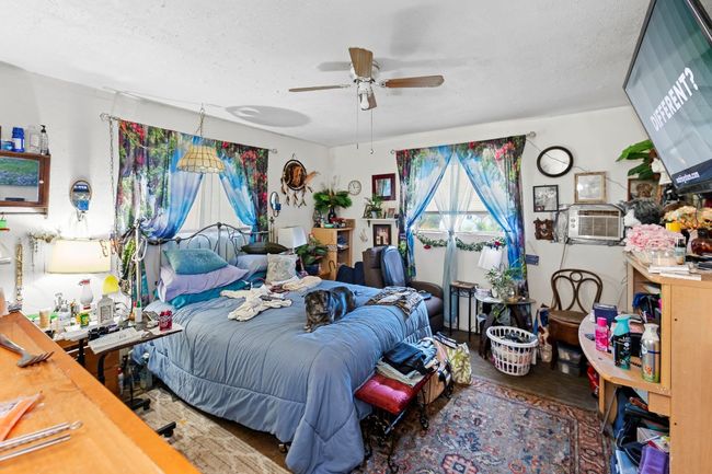 Bedroom with cooling unit, a textured ceiling, and ceiling fan | Image 14