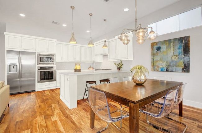 Kitchen featuring light countertops, built in appliances, white cabinetry, and visible vents | Image 11