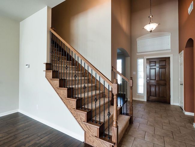 Foyer entrance featuring arched walkways, a high ceiling, baseboards, and stairs | Image 24