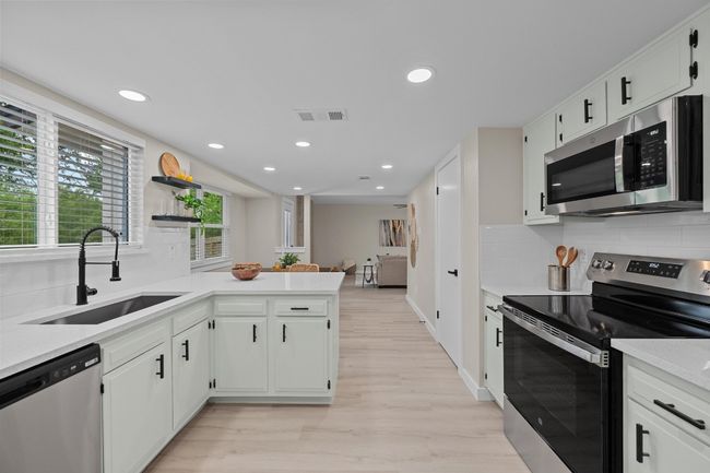 Kitchen featuring light countertops, a sink, a peninsula, stainless steel appliances, and visible vents | Image 10
