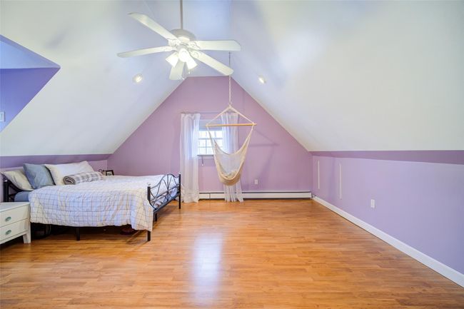 Bedroom 2 with baseboards, a ceiling fan, light wood finished floors, and lofted ceiling | Image 27
