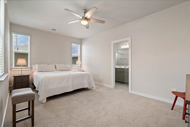 Bedroom with light colored carpet, ensuite bath, and a ceiling fan | Image 13