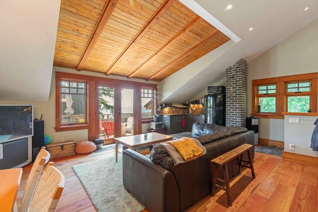 Living area with hardwood / wood-style flooring, wooden ceiling with exposed beams, plenty of natural light, french doors, and high vaulted ceiling | Image 26