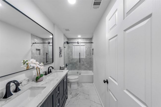 Full bathroom featuring double vanity, shower / tub combination, marble finish floors, and recessed lighting | Image 12