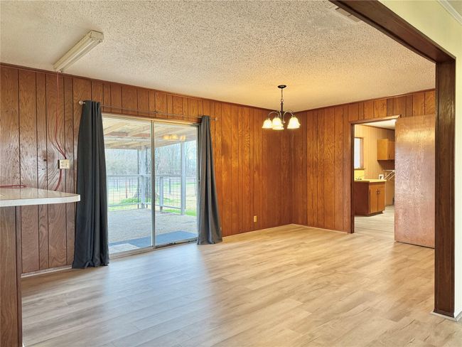 Unfurnished dining area with a chandelier, light hardwood / wood-style flooring, and a textured ceiling | Image 17