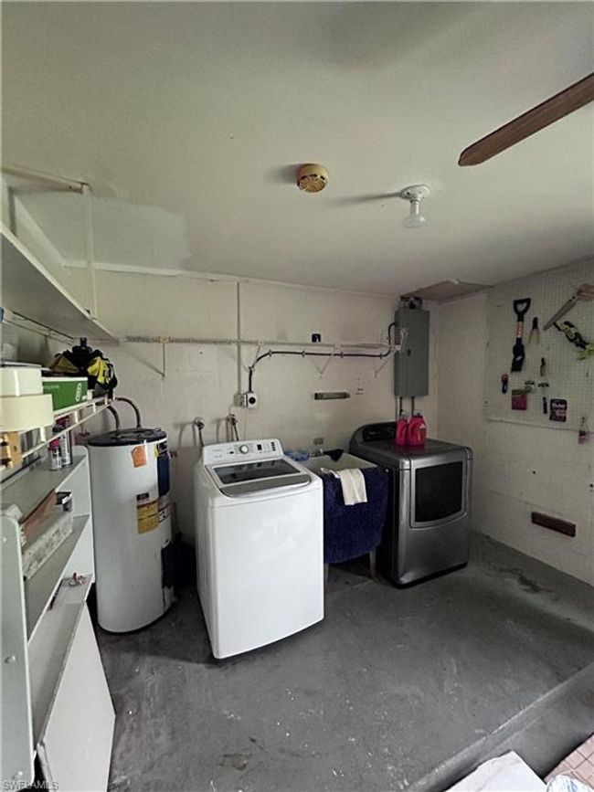 Laundry room featuring washer and dryer, electric panel, and water heater | Image 8