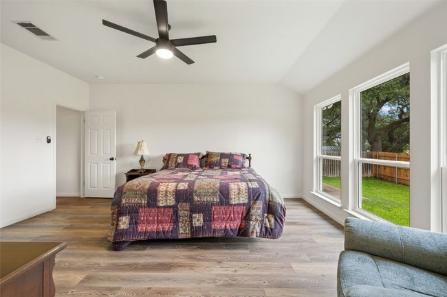Bedroom with vaulted ceiling, wood finished floors, and a ceiling fan | Image 26