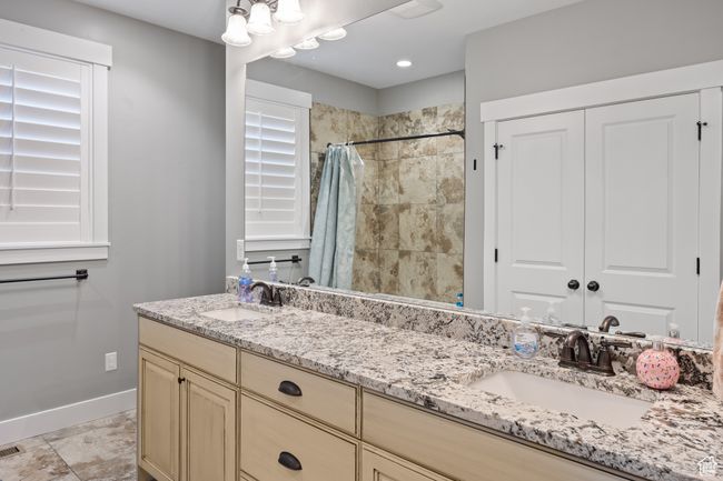 Full bath with double vanity, baseboards, and a tile shower | Image 42