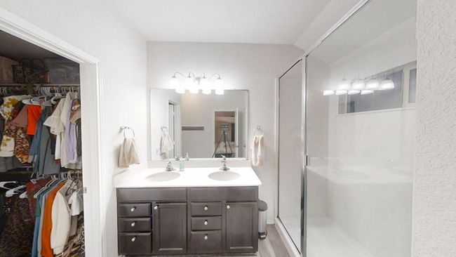 Bathroom with double vanity, a shower stall, and a walk in closet | Image 24