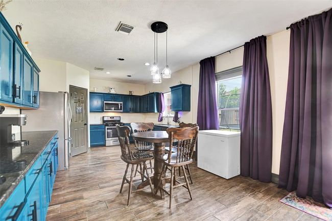 This kitchen features abundant cabinetry and elegant granite countertops. | Image 18