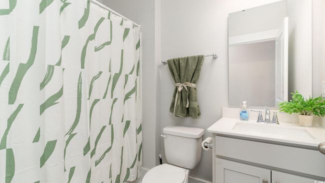 Bathroom with vanity, toilet, and a shower with curtain | Image 31