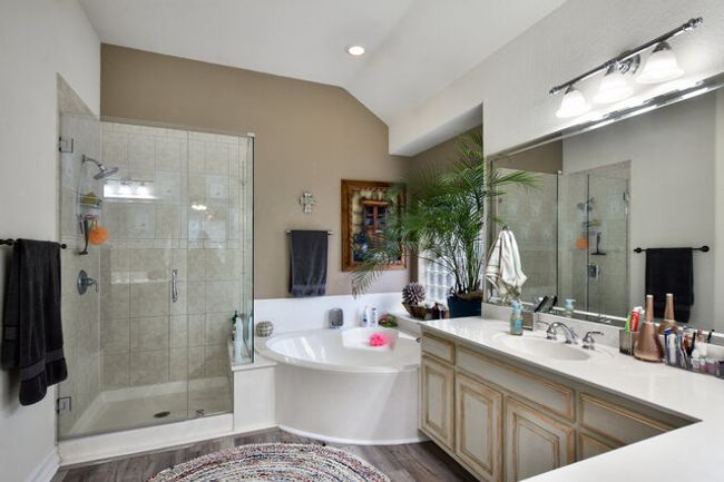 Full bathroom featuring wood finished floors, a bath, vanity, a stall shower, and vaulted ceiling | Image 19