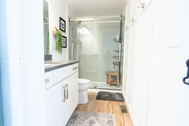 Full bathroom with a stall shower, wood finished floors, toilet, and vanity | Image 17