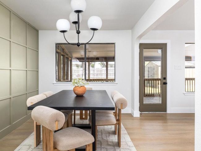 Dining room with baseboards, a chandelier, and light wood-type flooring | Image 13