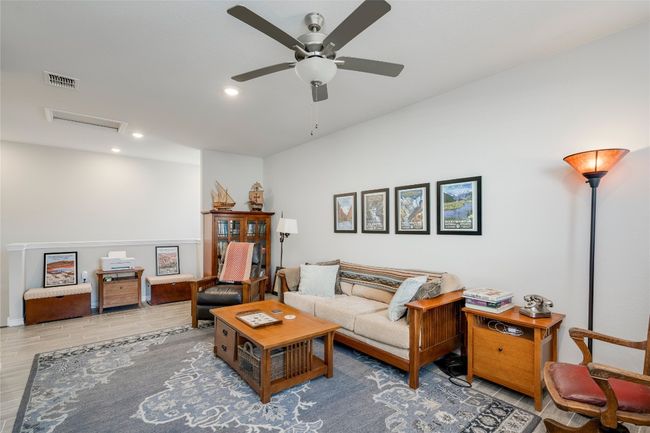 Living area with attic access, wood finished floors, visible vents, ceiling fan, and recessed lighting | Image 21