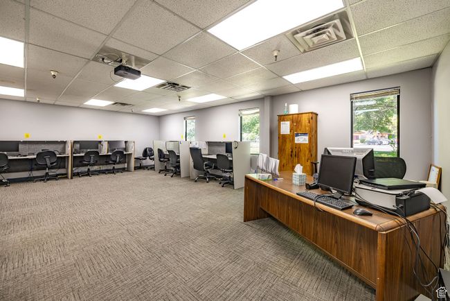 Home office featuring a drop ceiling, healthy amount of natural light, and carpet floors | Image 20