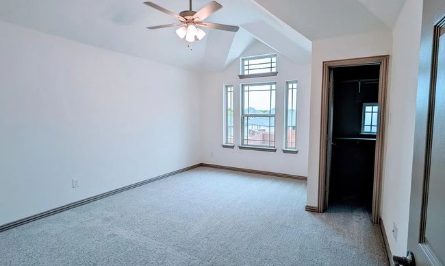 Unfurnished bedroom featuring lofted ceiling, carpet flooring, baseboards, and a ceiling fan | Image 15