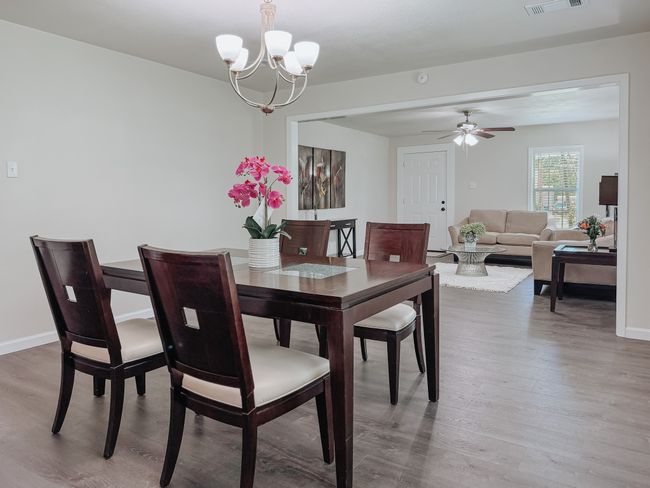 Dining area featuring wood finished floors, a chandelier, and ceiling fan | Image 9