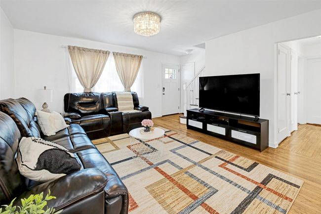Living area featuring wood finished floors, a chandelier, and baseboards | Image 6