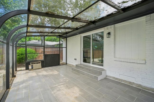Unfurnished sunroom featuring a wall mounted AC and entry steps | Image 34