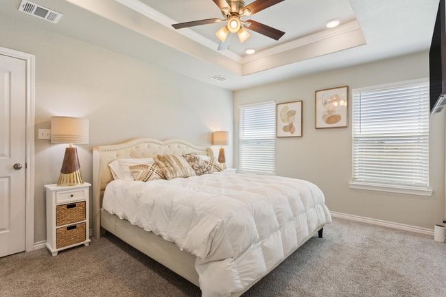 Carpeted bedroom with crown molding, a raised ceiling, recessed lighting, and ceiling fan | Image 17