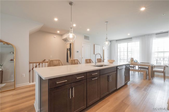 Kitchen featuring a sink, light wood-type flooring, dishwasher, light countertops, and visible vents | Image 9