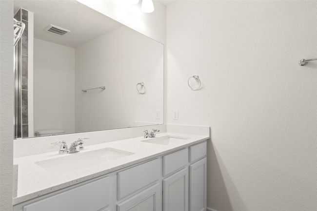 Full bath with double vanity, toilet, visible vents, and a sink | Image 22