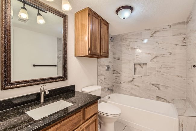 Bathroom with vanity, visible vents, toilet, shower / tub combination, and a textured ceiling | Image 15