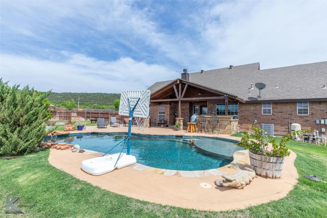 View of pool featuring a patio area, central AC unit, and a ceiling fan | Image 33