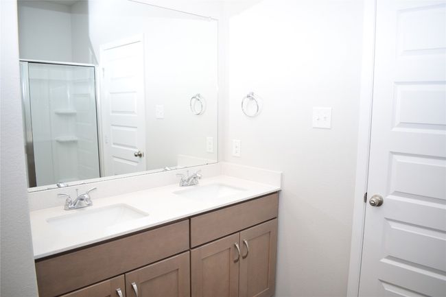 Bathroom featuring double vanity and a shower stall | Image 13