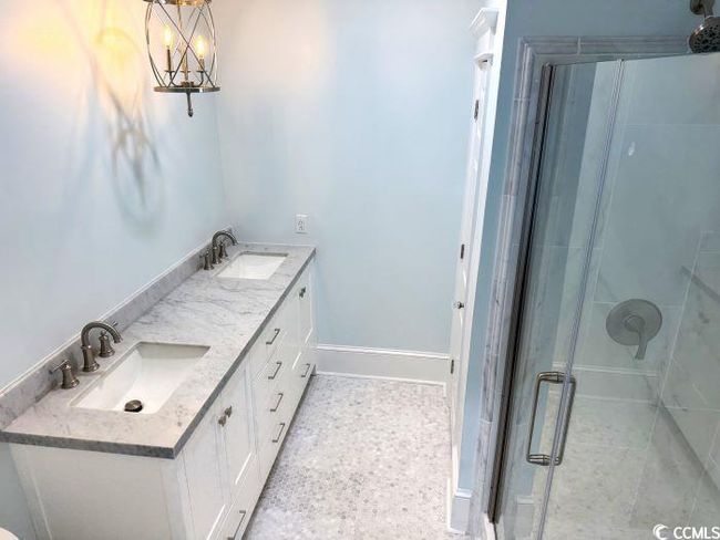 Bathroom with a shower with shower door, vanity, and a notable chandelier | Image 27