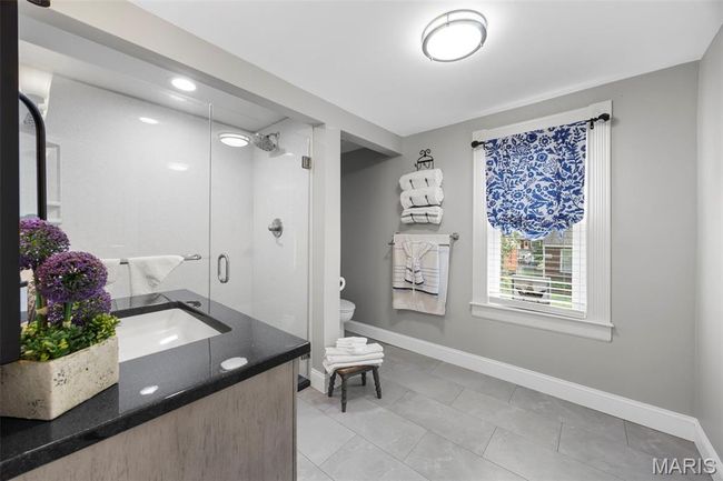 Full bath featuring tile patterned floors, a stall shower, and vanity | Image 18