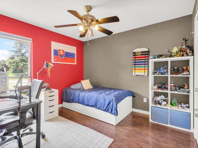 Bedroom with wood finished floors, a desk, and ceiling fan | Image 20