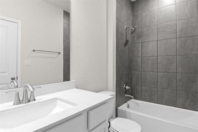 Bathroom with bathtub / shower combination, a textured wall, toilet, and vanity | Image 27