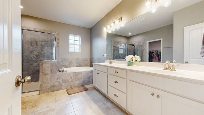Huge primary en suite bathroom with separate tub & shower, double vanities, water closet for the toilet, and large walk-in closet | Image 29
