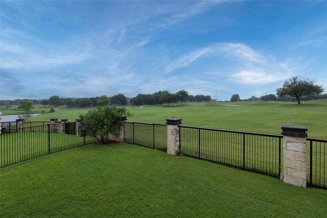 View of the yard with a water view, golf course view, and a wrought iron fenced backyard | Image 33