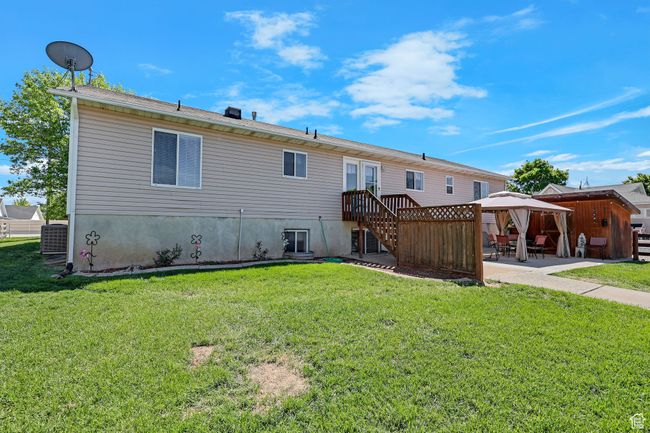 Back of house featuring a gazebo, a patio area, a yard, and central air condition unit | Image 34