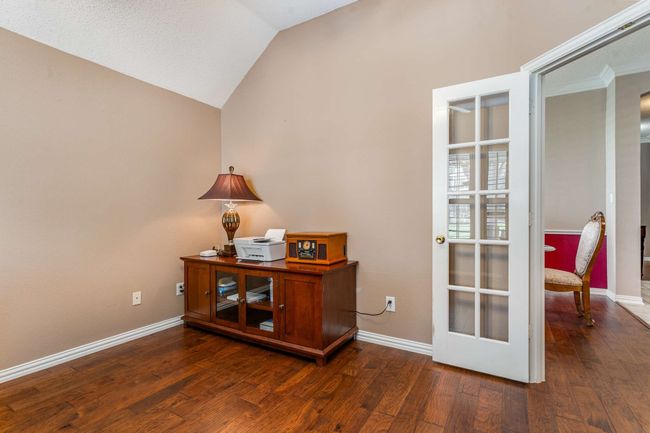 Office area featuring wood finished floors, baseboards, and vaulted ceiling | Image 9