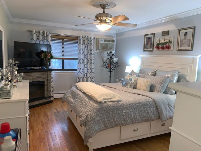 Extra large bedroom (can fit any size furniture) has wood floors, crown molding, a ceiling fan and lots of closet space - small walk in closet plus a second closet | Image 10