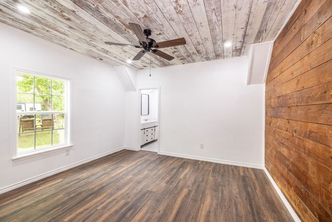 Spare room with dark wood-style flooring, ceiling fan, baseboards, and wood ceiling | Image 11