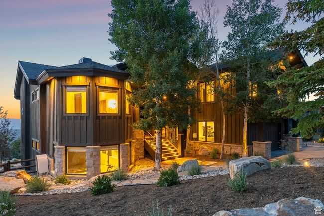 View of front of home with board and batten siding, stone siding, a shingled roof, and stairway | Image 92
