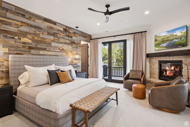 Bedroom featuring access to outside, a fireplace, wooden walls, recessed lighting, and carpet | Image 66