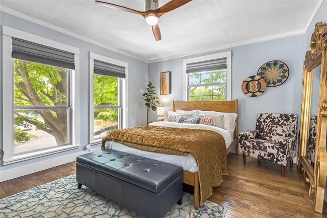 Bedroom with multiple windows, ornamental molding, wood finished floors, and ceiling fan | Image 21