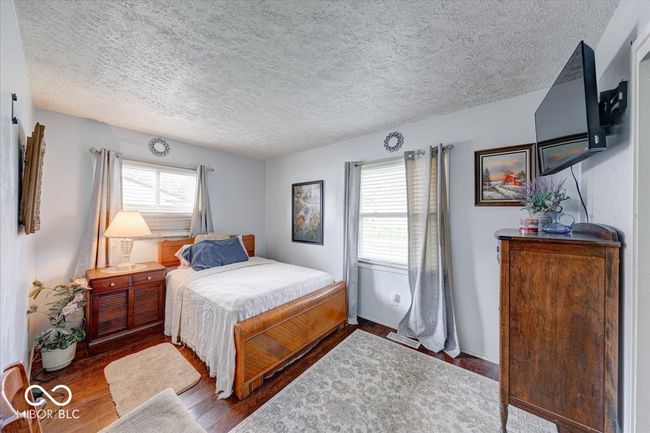 bedroom #2 with multiple windows, wood finished floors, and a textured ceiling | Image 30