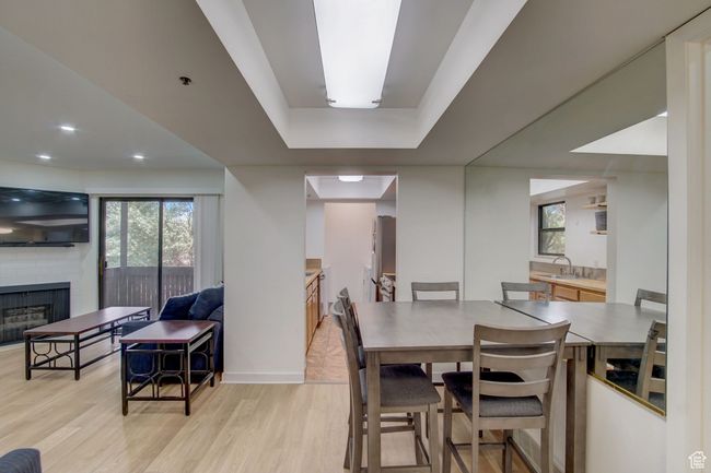 Dining area with a brick fireplace, light wood-type flooring, sink, and a healthy amount of sunlight | Image 8