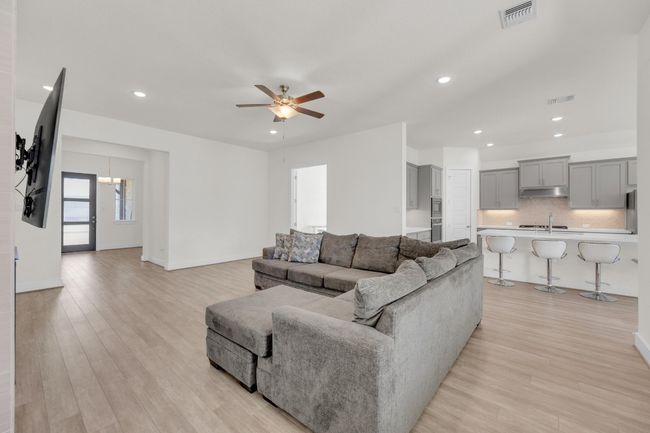 Living area featuring ceiling fan, recessed lighting, visible vents, and light wood-style floors | Image 11