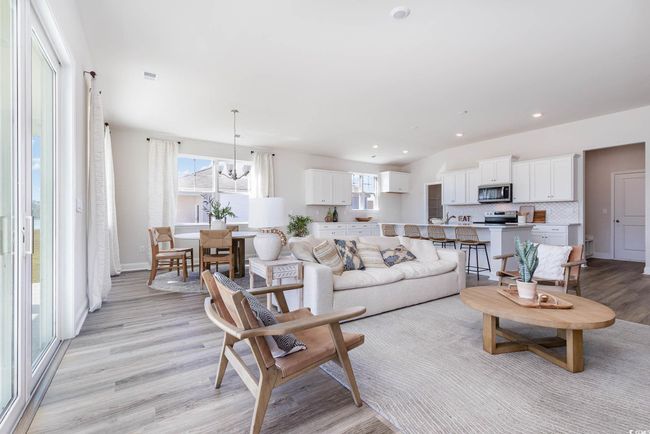 Living area with light wood-type flooring, a chandelier, recessed lighting, and baseboards | Image 19