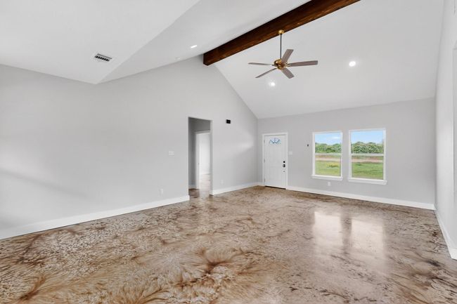 Empty room with high vaulted ceiling, beam ceiling, a ceiling fan, and recessed lighting | Image 16