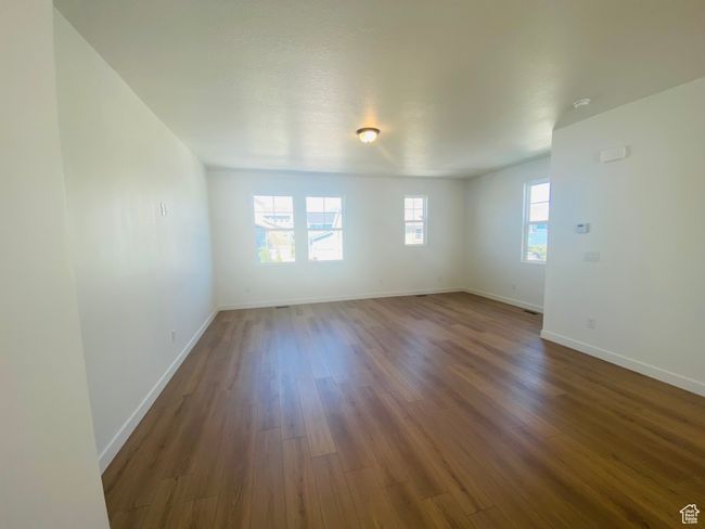 Unfurnished room with dark wood-style floors and baseboards | Image 5